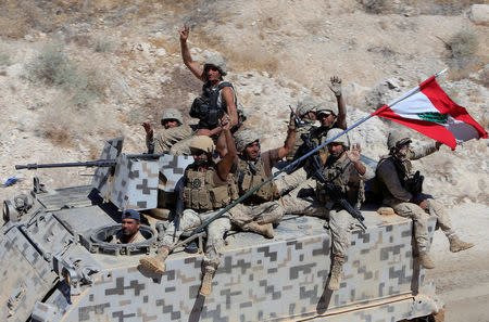 FILE PHOTO: Lebanese army soldiers gesture as they sit on their military vehicles in the town of Ras Baalbek, Lebanon August 21, 2017. REUTERS/ Ali Hashisho/ File Photo