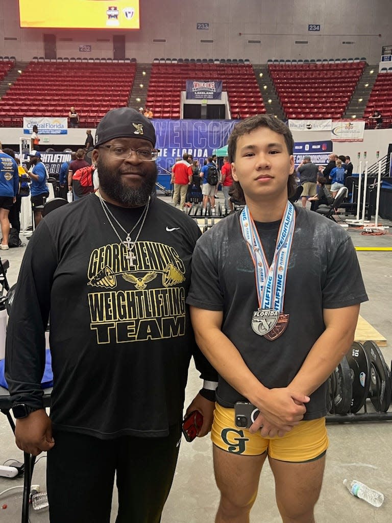 Standing here are George Jenkins head weightlifting coach John Freeman, left, and weightlifter William Draper. Draper took third place in the 2024 FHSAA state boys weightlifting championship.