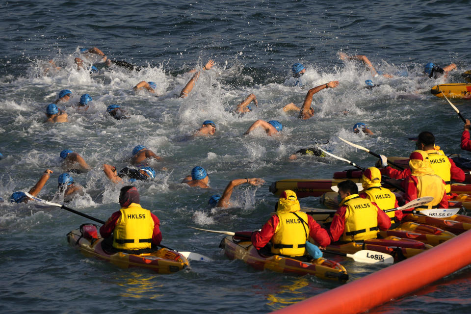 Competitors swim during a harbor race at the Victoria Harbor in Hong Kong, Sunday, Dec. 12, 2021. Hundreds of people took part in traditional swim across iconic Victoria Harbor after two years of suspension. (AP Photo/Kin Cheung)