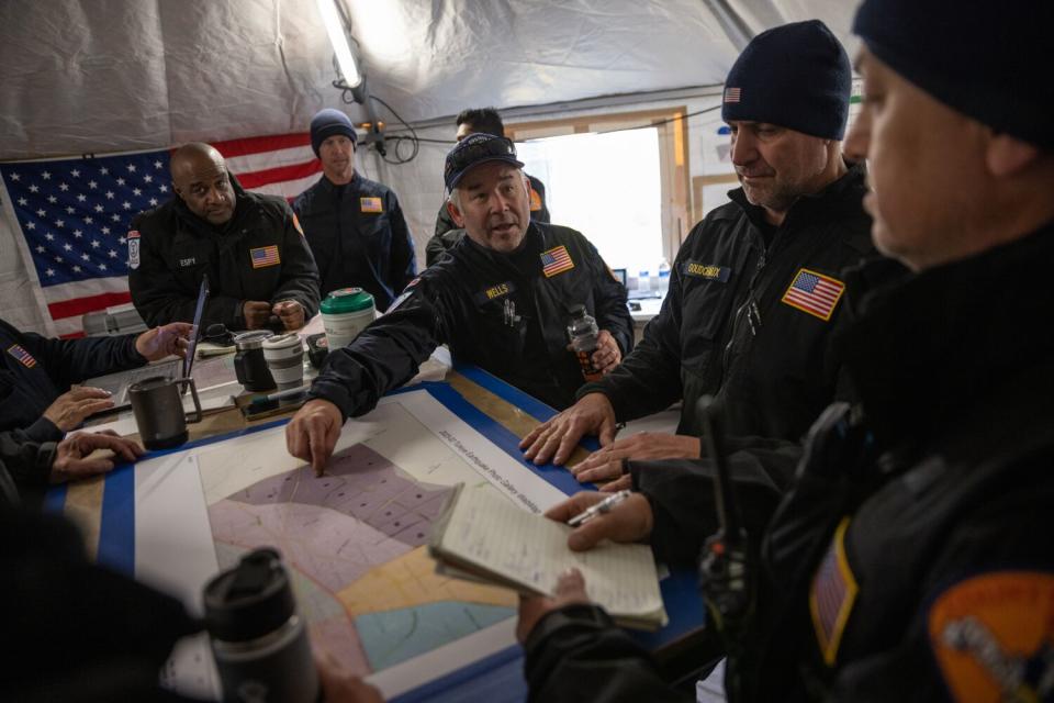 Members of the USAID Los Angeles County Fire Department Urban Search and Rescue team hold a meeting