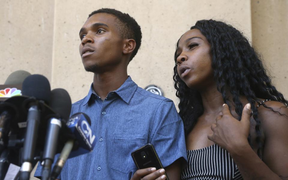 Iesha Harper, right, answers a question during a news conference as she is joined by her fiancee Dravon Ames, left, at Phoenix City Hall, Monday, June 17, 2019, in Phoenix. Ames and his pregnant fiancée, Harper, who had guns aimed at them by Phoenix police during a response to a shoplifting report, say they don't accept the apologies of the city's police chief and mayor and want the officers involved to be fired.(AP Photo/Ross D. Franklin)