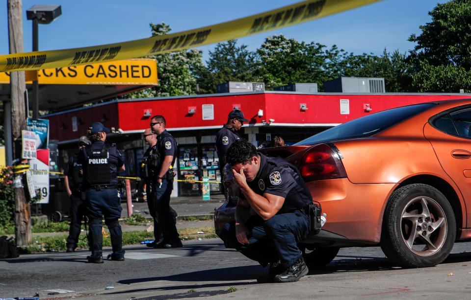 Louisville police were on guard inside police tape at the intersection of 26th and Broadway on June 1 after a man was shot and killed by police and National Guard personnel outside Dino's Market.