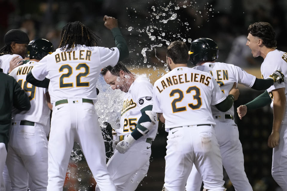 Oakland Athletics' Brent Rooker (25) is congratulated by teammates after hitting a two-run home run against the Kansas City Royals during the ninth inning of a baseball game in Oakland, Calif., Monday, Aug. 21, 2023. (AP Photo/Jeff Chiu)
