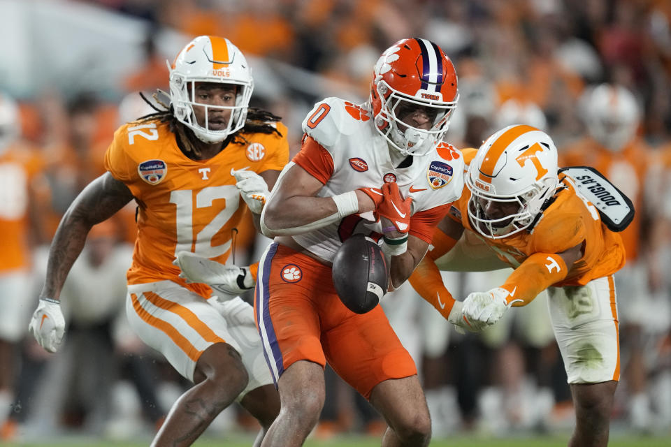 Clemson wide receiver Antonio Williams (0) loses his grip on a pass under pressure from Tennessee defensive backs Tamarion McDonald (12) and Wesley Walker, right, during the first half of the Orange Bowl NCAA college football game, Friday, Dec. 30, 2022, in Miami Gardens, Fla. (AP Photo/Rebecca Blackwell)