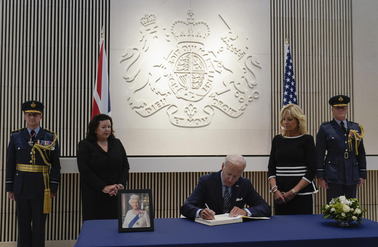 President Joe Biden signs a condolence book at the British Embassy in Washington, Thursday, Sept. 8, 2022, for Queen Elizabeth II. First lady Jill Biden, second from right, and British ambassador Karen Pierce, second from left, look on. (AP Photo/Susan Walsh)