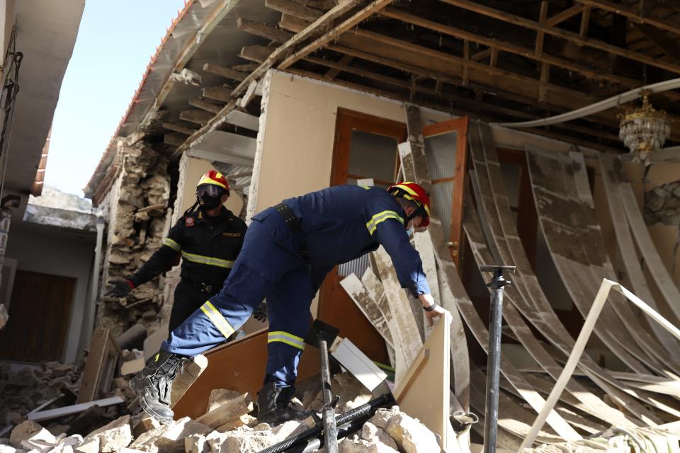 Firefighters search inside a damaged house after an earthquake in Damasi village, central Greece, Thursday, March 4, 2021. Fearful of returning to their homes, many thousands of people in central Greece spent the night outdoors after a powerful earthquake Wednesday, felt across the region leaving many damaged homes and public buildings.(AP Photo/Vaggelis Kousioras)