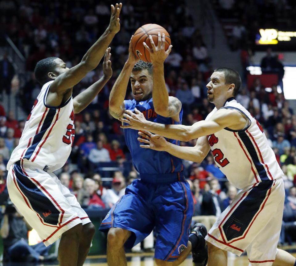 Florida guard Scottie Wilbekin (5) is closely defended by Mississippi guard Jarvis Summers, left, and Marshall Henderson in the first half of an NCAA college basketball game in Oxford, Miss., Saturday, Feb. 22, 2014. (AP Photo/Rogelio V. Solis)