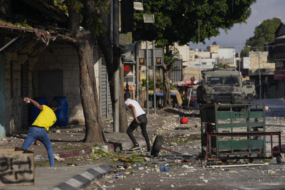 Palestinian demonstrators clash with the Israeli army while forces carry out an operation in the West Bank town of Nablus, Tuesday, Aug. 9, 2022. (AP Photo/Majdi Mohammed)