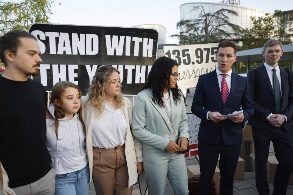 From left, siblings Martim, Mariana and Claudia Agostinho, Catarine Mota, and lawyer Gearoid o Cuinn talk to media outside the European Court of Human Rights, where they are accusing 32 European governments of violating their human rights for what they say is a failure to adequately address climate change, Wednesday, Sept. 27, 2023, in Strasbourg. (AP Photo/Jean-Francois Badias)