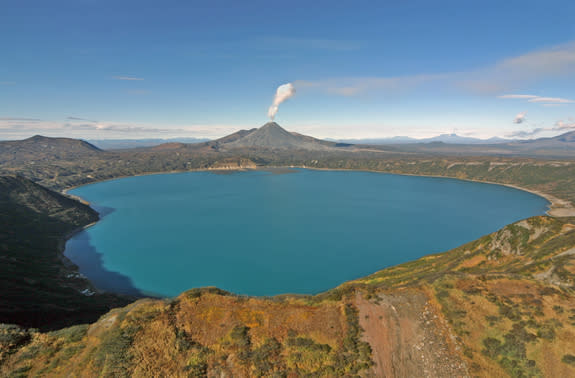 Karymsky Lake, with the peak of Karymsky volcano steaming in the background.