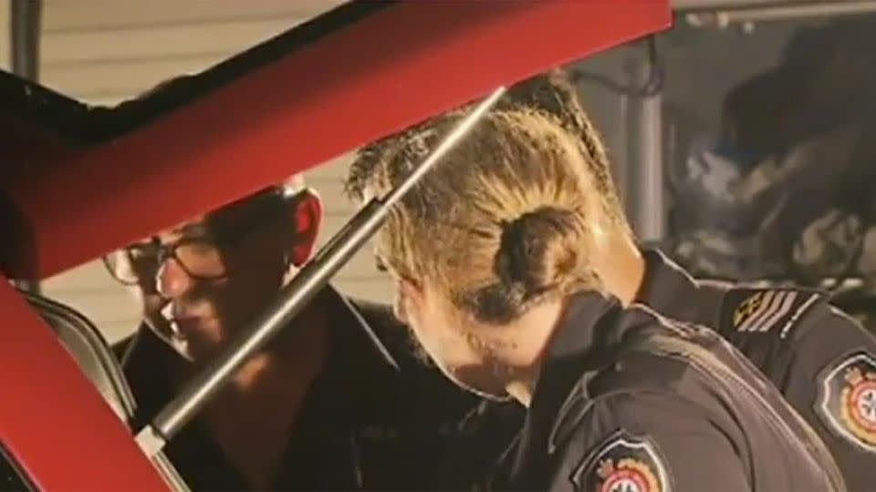 Police officers inspecting the car which ran over the woman and her son. Photo: 7 News