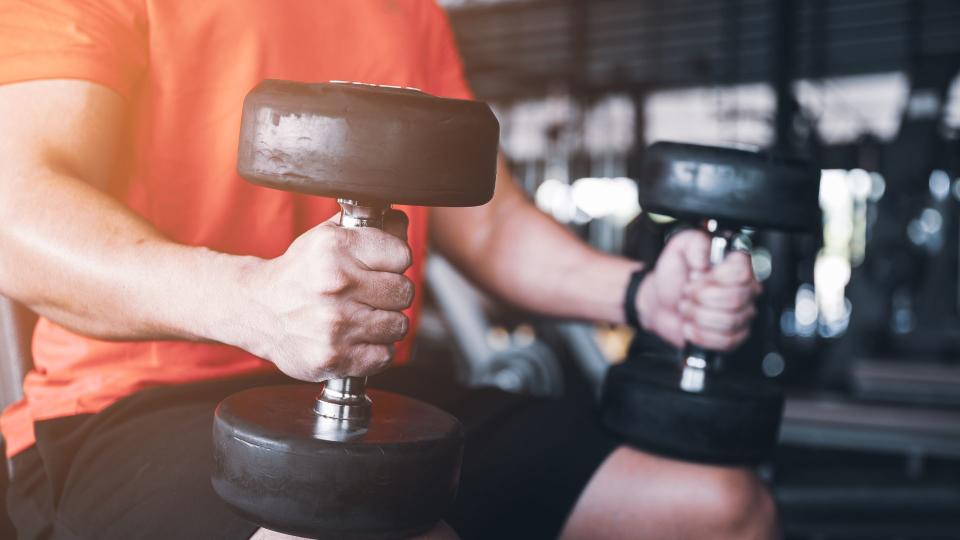 Man performing seated dumbbell calf raises