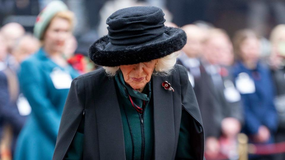 Queen Camilla pauses after placing memorial cross