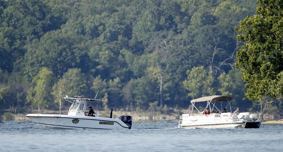 Emergency workers patrol an area Friday, July 20, 2018, near where a duck boat capsized the night before. Source: AP Photo