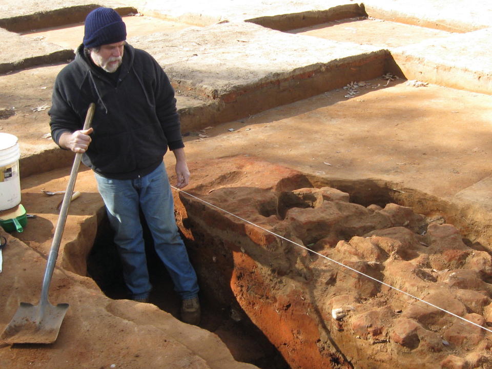 In this Jan. 30, 2014 photo, University of South Carolina archaeologist James Legg digs in the location of a hole that was once used by some of the 1,500 Union Army officers held at "Camp Aslyum" in Columbia, S.C., in the winter of 1864-65. The prisoners dug holes to protect themselves when they were imprisoned on the grounds of the former state mental hospital. Researchers are finding buttons, cups, bits of clothing and other articles on the site. South Carolina archeologists are digging to uncover the remnants of the Civil War-era prisoner-of-war camp before the site in downtown Columbia is cleared to make room for a mixed-use development. (AP Photo/Susanne Schafer)