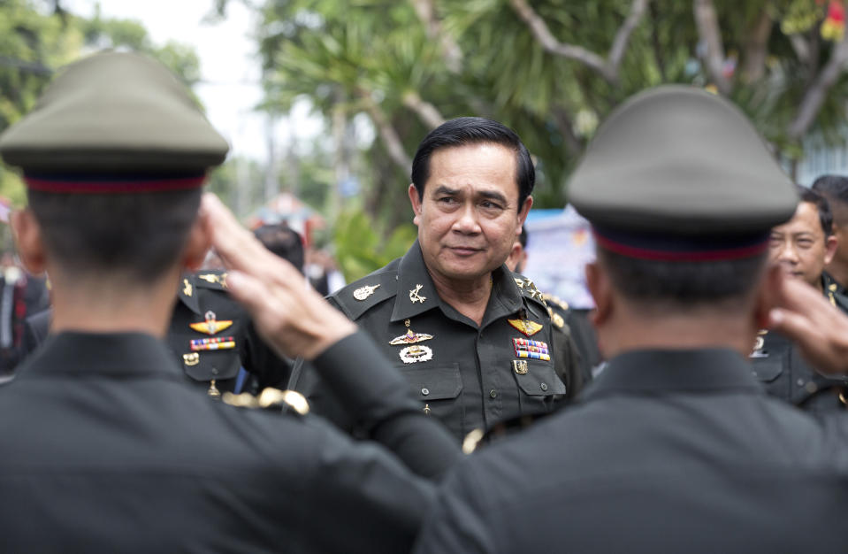 FILE - In this Thursday, Aug. 21, 2014, file photo, Thailand's Prime Minister Prayuth Chan-ocha, center, arrives for an anniversary ceremony for the 21st infantry regiment, Queen's Guard, in Chonburi Province, Thailand. Prayuth became prime minister in a very Thai way: He led a military coup. Now after five years of running Thailand with absolute power, he’s seeking to hold on to the top job through the ballot box. The military's thinly veiled proxy party has put forward Prayuth as its nominee for prime minister after Sunday’s election. But running the show in an elected government may not be as easy though since he’ll no longer be able to muzzle opponents and rely on a rubberstamp legislature. (AP Photo/Sakchai Lalit, File)