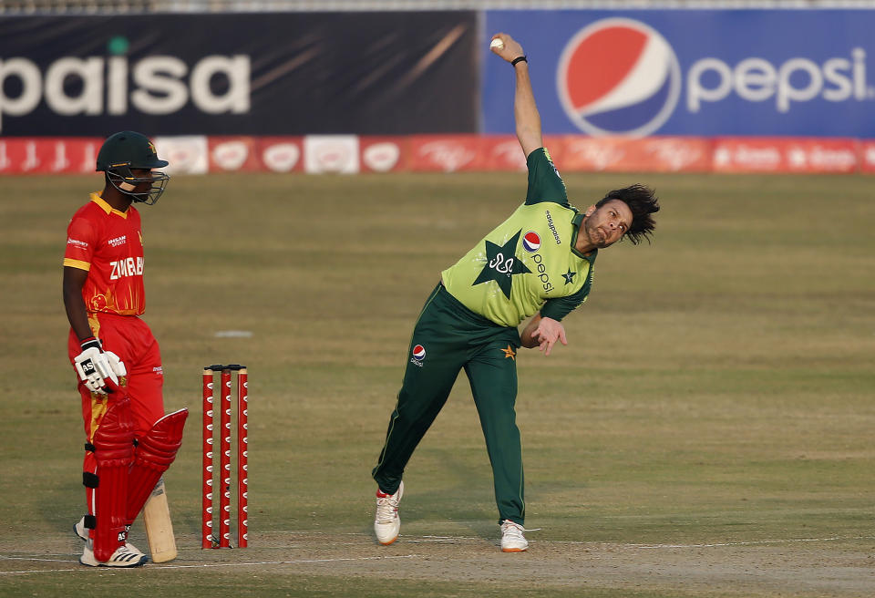 Pakistani spinner Usman Qadir, right, delivers a ball while Zimbabwe's batsman Wessley Madhevere during their 3rd Twenty20 cricket match at the Pindi Cricket Stadium, in Rawalpindi, Pakistan, Tuesday, Nov. 10, 2020. (AP Photo/Anjum Naveed)