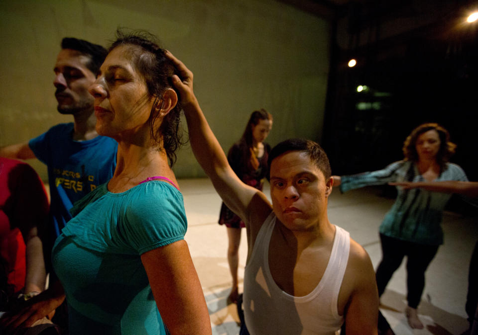 In this Dec. 4, 2018 photo, dancers practice prior to their last performance in the contemporary dance production Ubuntu, at the Teresa Carreno Theater in Caracas, Venezuela. Caracas based AM Danza works with 50 young Venezuelans who are pursuing their passion for dance despite limitations like broken spines, cerebral palsy, Down syndrome or blindness. (AP Photo/Fernando Llano)