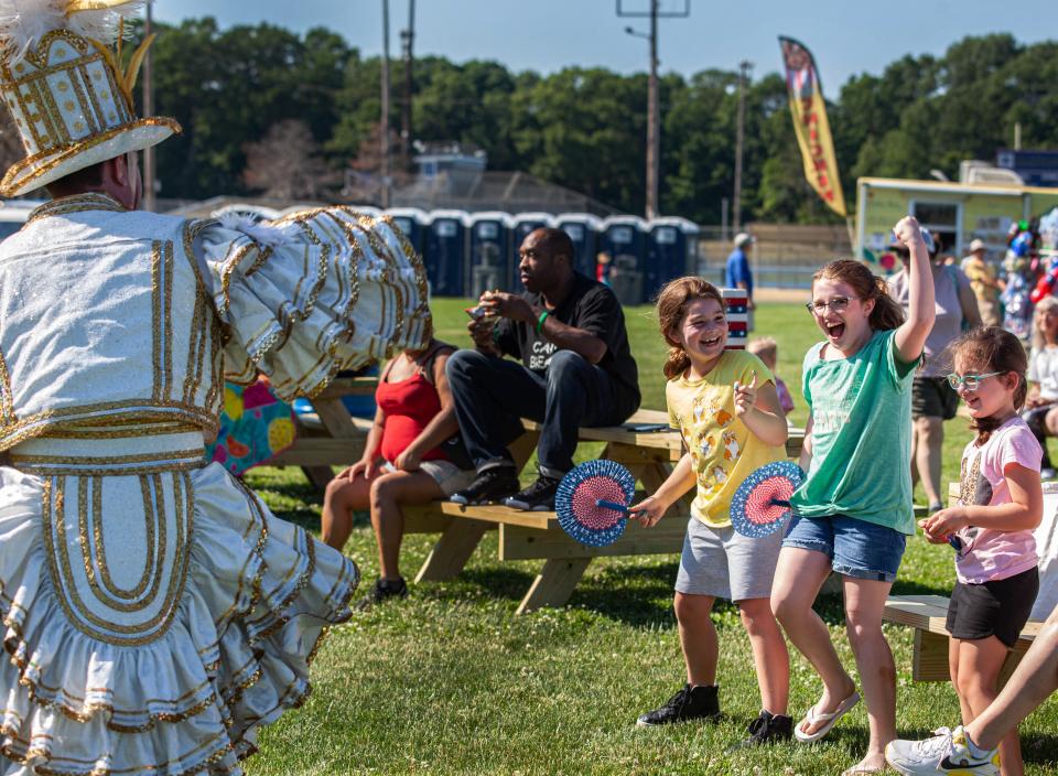 Lillian Kelley, 8, Penny Dalton, 8, and Emma Kelley, 6, dance with a performer during Braintree Day on Saturday, June 25, 2022.