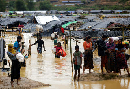 Rohingya refugees leave their makeshift shelters as they are flooded due to heavy rain, in Cox's Bazar, Bangladesh, September 19, 2017. REUTERS/Mohammad Ponir Hossain