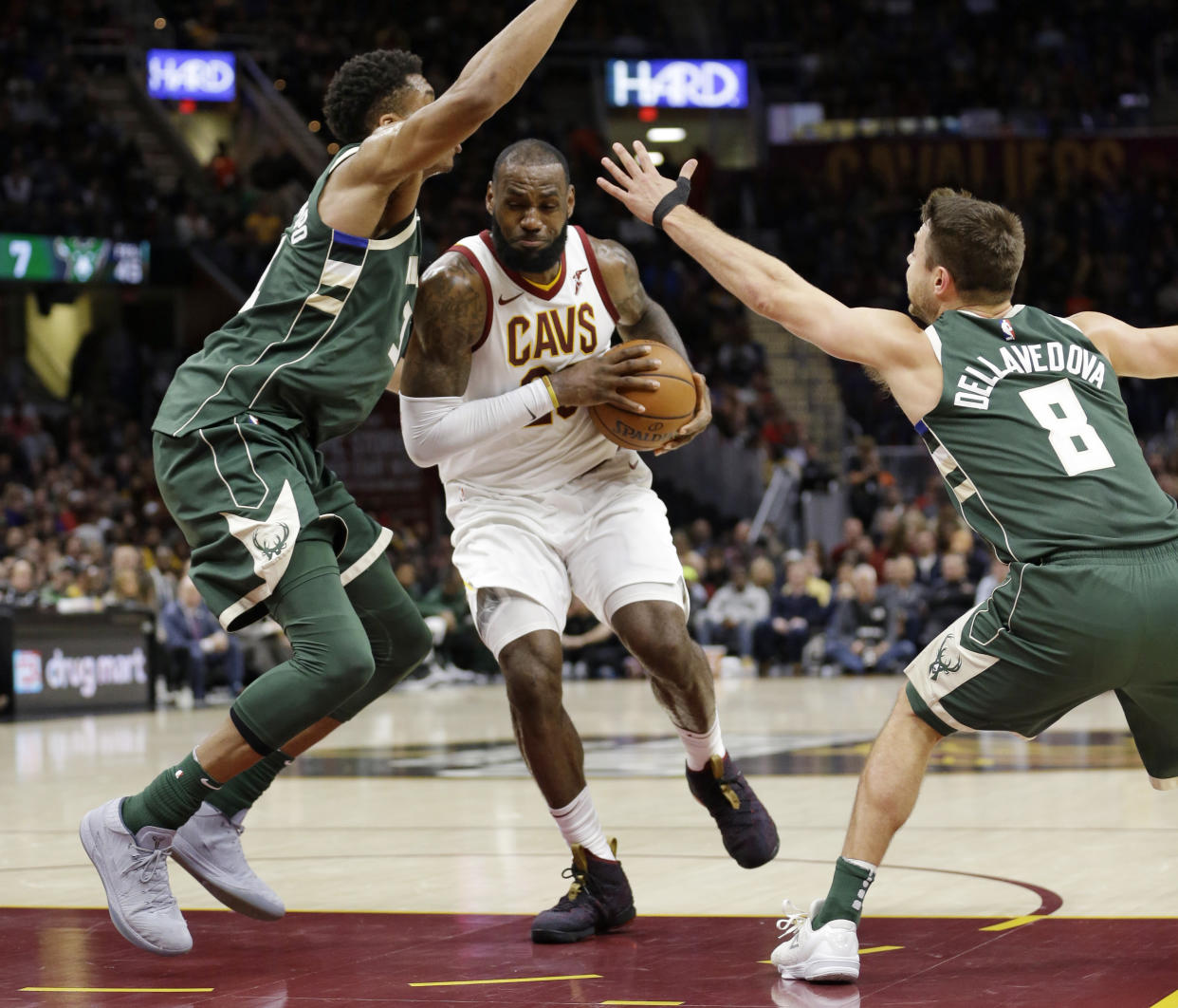LeBron James drives through Giannis Antetokounmpo (and, to a lesser extent, Matthew Dellavedova) on his way to the cup. (AP)