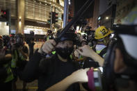 Police push back media on the street of Yuen Long, Hong Kong, Monday, Oct. 21, 2019. A evening sit-in at a suburban train station on the three-month anniversary of a violent attack there on protesters by men with suspected organized crime ties. (AP Photo/Mark Schiefelbein)