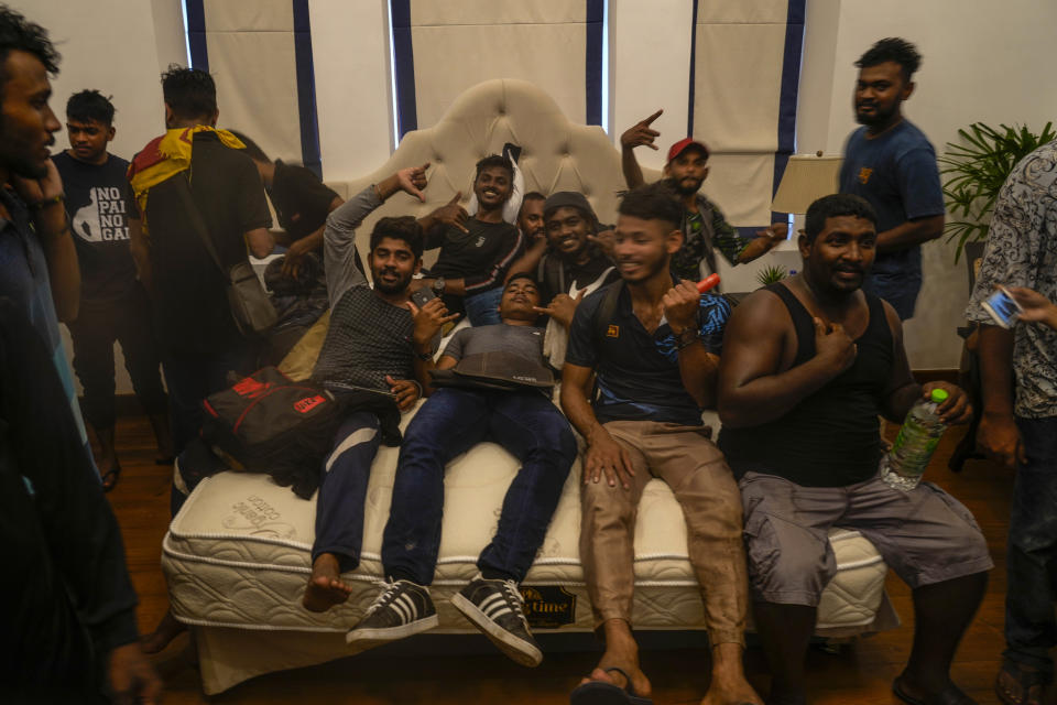 Protesters lie on a bed after storming the Sri Lankan Prime Minister Ranil Wickremesinghe's office, demanding he resign after president Gotabaya Rajapaksa fled the country amid economic crisis in Colombo, Sri Lanka, Wednesday, July 13, 2022. Rajapaksa fled on a military jet on Wednesday after angry protesters seized his home and office, and appointed Prime Minister Ranil Wickremesinghe as acting president while he is overseas. Wickremesinghe quickly declared a nationwide state of emergency to counter swelling protests over the country's economic and political collapse. (AP Photo/ Photo/Rafiq Maqbool)