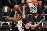 Milwaukee Bucks forward Giannis Antetokounmpo (34), center, drives to the basket against Brooklyn Nets forward Joe Harris during the second half of an NBA basketball game Monday, Jan. 18, 2021, in New York. (AP Photo/Adam Hunger)