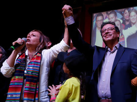 Colombian presidential candidate Gustavo Petro holds the hand of his vice presidential candidate Angel Maria Robledo after polls closed in the first round of the presidential election in Bogota, Colombia May 27, 2018. REUTERS/Henry Romero
