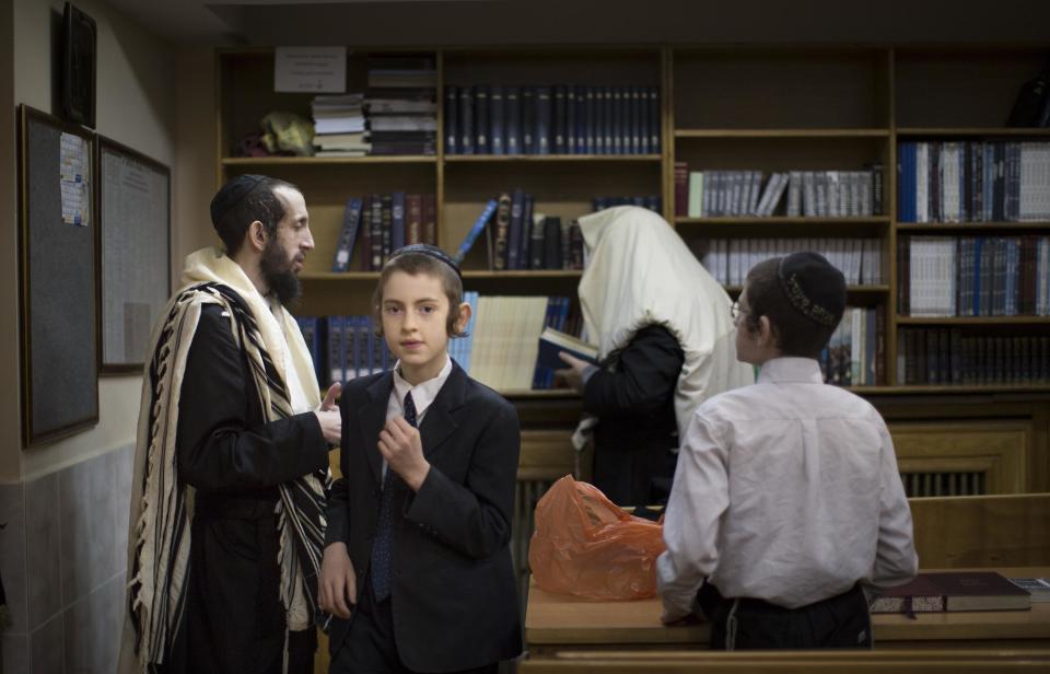 Jewish men and boys prepare to read prayers in a synagogue in Donetsk, Ukraine, Friday, April 18, 2014. A leaflet distributed in Donetsk, Ukraine calling for all Jews over 16 years old to register as Jews marred the Jewish community's Passover festivities for Monday (Passover eve), replacing them with feelings of concern. Leaders of pro-Russian insurgents in Donetsk where leaflets were distributed flatly denied being behind the distribution, describing it as a fake and provocation. (AP Photo/Alexander Zemlianichenko)