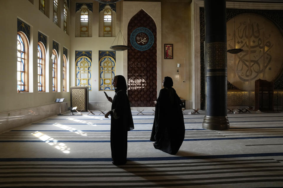 Virag Sarkadi, left, a 19 years old Hungarian tourist, visits Katara mosque in Doha, Qatar, Tuesday, Dec. 6, 2022. (AP Photo/Jorge Saenz)