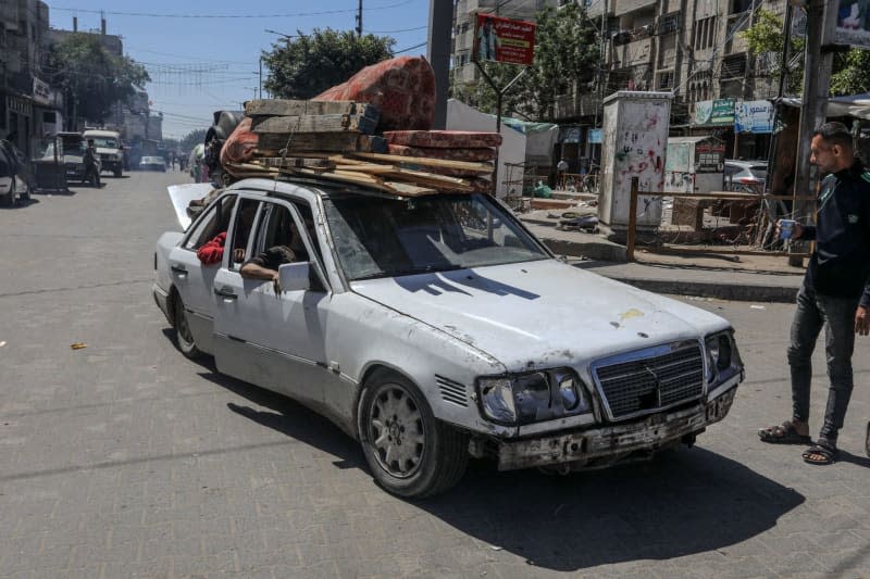 Palestinians carry their belongings on a vehicle as they flee following Israeli airstrikes on Al-Geneina and Al-Salam neighbourhoods. Abed Rahim Khatib/dpa