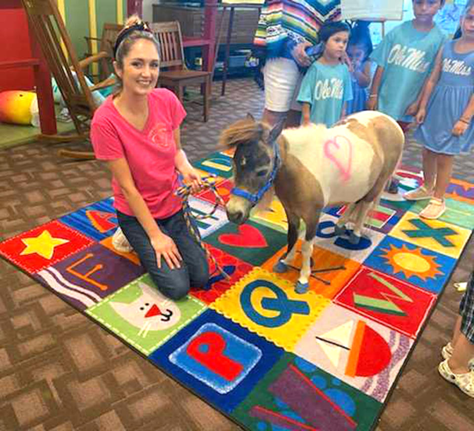 A volunteer poses with a pony inside El Progreso Memorial Library. The pony is house trained, thankfully. (Courtesy of Mendell Morgan)