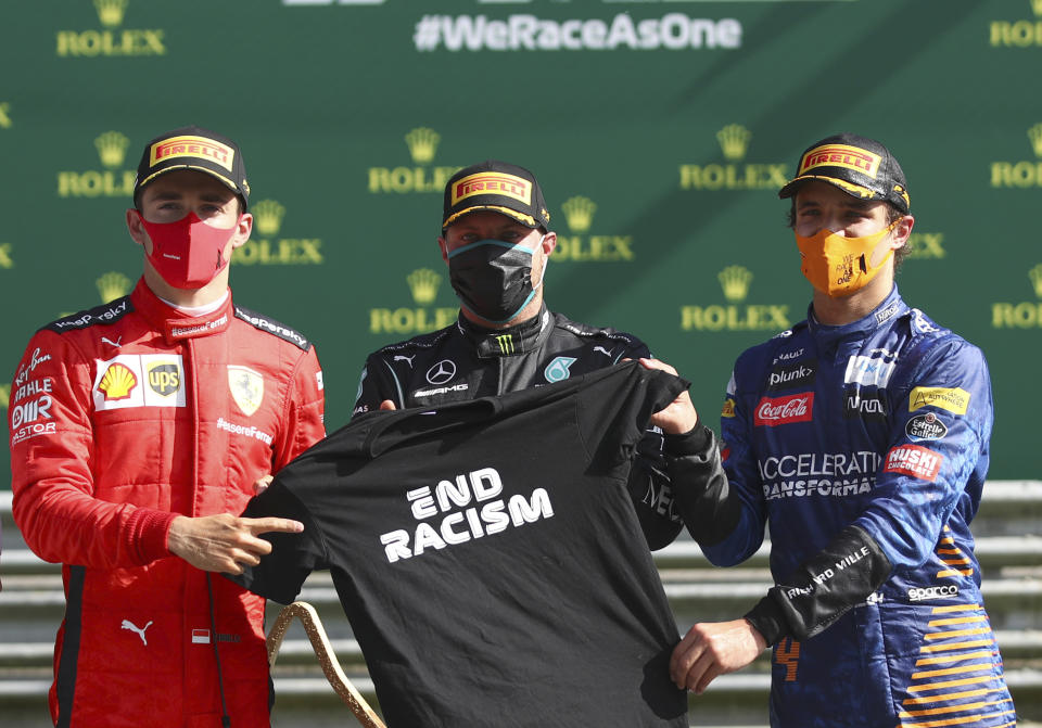 Race winner Mercedes driver Valtteri Bottas of Finland, centre, pose with second placed Ferrari driver Charles Leclerc of Monaco, left, and third placed Mclaren driver Lando Norris of Britain after the Austrian Formula One Grand Prix at the Red Bull Ring racetrack in Spielberg, Austria, Sunday, July 5, 2020. (Mark Thompson/Pool via AP)