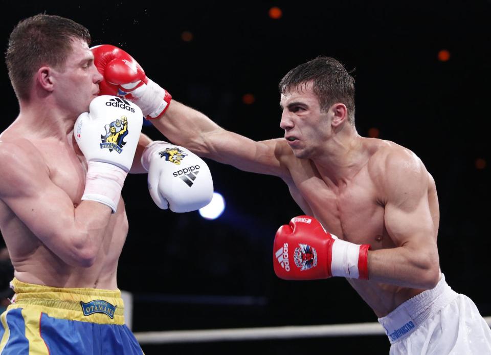 Russia's Radzhab Butaev, right, punches Ukraine's Denis Berinchyk during their light welterweight 64-kg World Series of Boxing quarterfinal bout between Russian Boxing Team and Ukraine Otamans, in Moscow, Russia, Monday, March, 31, 2014. Second leg matches will take part in Donetsk, Ukraine, on April 4. (AP Photo/Denis Tyrin)