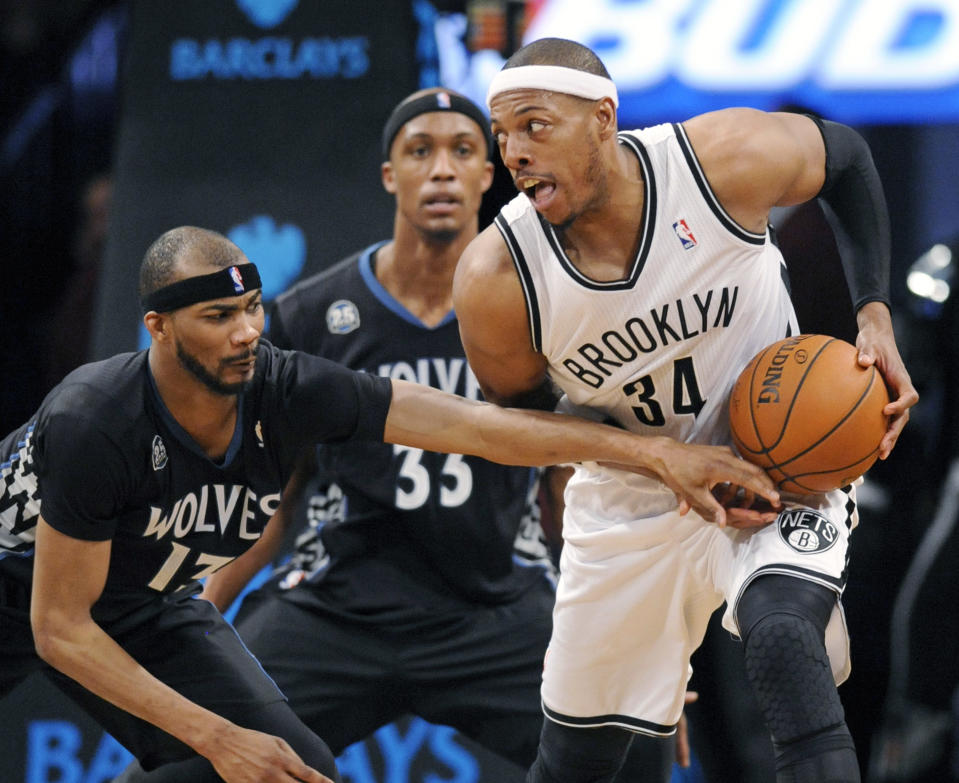 Brooklyn Nets' Paul Pierce, right, protects the ball from Minnesota Timberwolves' Corey Brewer during the fourth quarter of an NBA basketball game, Sunday, March 30, 2014, at Barclay's Center in New York. The Nets won 114-99. (AP Photo/Bill Kostroun)