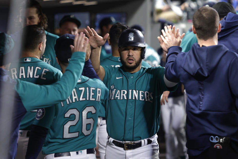 Seattle Mariners' Eugenio Suarez celebrates in the dugout after scoring on a Abraham Toro sacrifice fly during the fourth inning of the team's baseball game against the Tampa Bay Rays, Friday, May 6, 2022, in Seattle. (AP Photo/Jason Redmond)