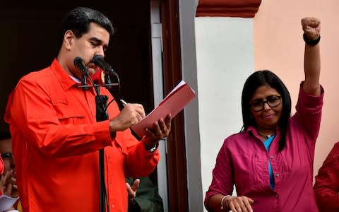 Venezuela's President Nicolas Maduro signs at a balcony at Miraflores Presidential Palace, a document through which his government breaks off diplomatic ties with the United States - Credit: &nbsp;LUIS ROBAYO/AFP