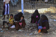 Rohingya refugees who are being moved to an island called ‘Bhasan Char’ gather outside a transit area where they are temporally housed in Ukhiya, Bangladesh, Thursday, Dec.3, 2020. (AP Photo/ Shafiqur Rahman)