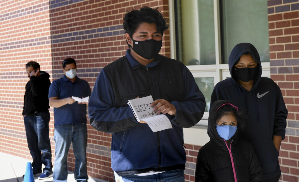 SILVER SPRING, MD - MARCH 26:    Max Alarcon, 17, waits with his sisters Lisa Cardenas, 6, and Yulianna Cardenas, 12,  to pick up Chromebooks during Montgomery County Public School's distribution at Bel Pre Elementary School on Thursday, March 26, 2020. Montgomery County is distributing Chromebook laptops for students who lack technology at home to use, as it looks to transition to distance learning amid the coronavirus pandemic. (Photo by Toni L. Sandys/The Washington Post via Getty Images)