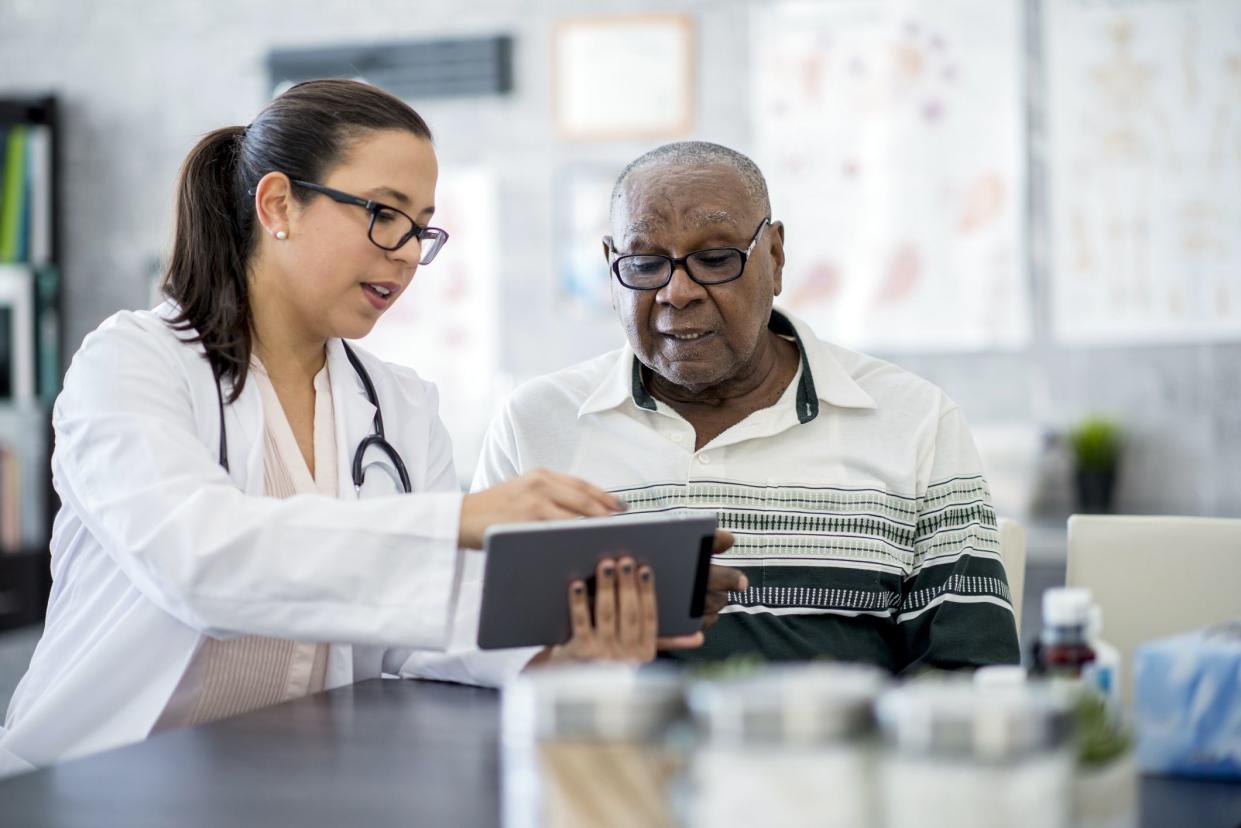 doctor showing senior something on tablet