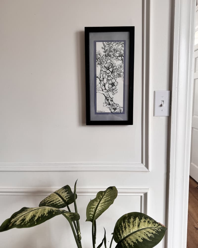 hallway with framed art covering old intercom