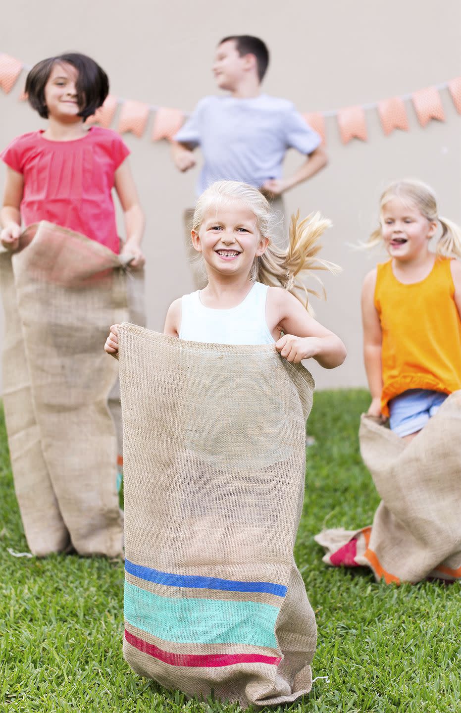 kids in burlap sacks competing in a sack race