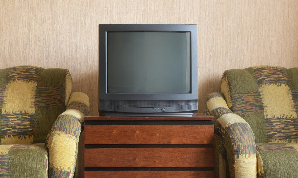 Old-fashioned television set between two patterned armchairs