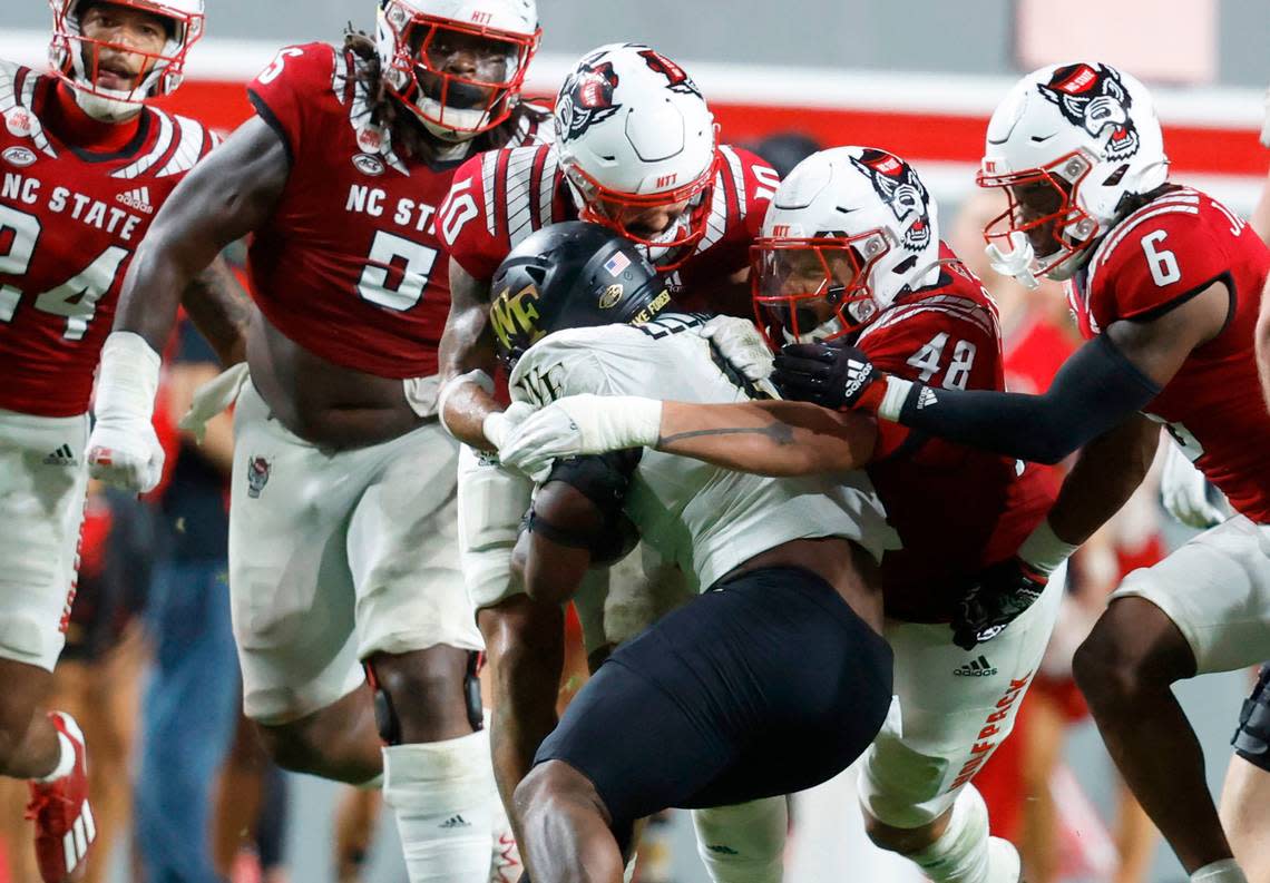 N.C. State’s Tanner Ingle (10) and Cory Durden (48) stop Wake Forest running back Justice Ellison (6) during the second half of N.C. State’s 30-21 victory over Wake Forest at Carter-Finley Stadium in Raleigh, N.C., Saturday, Nov. 5, 2022.