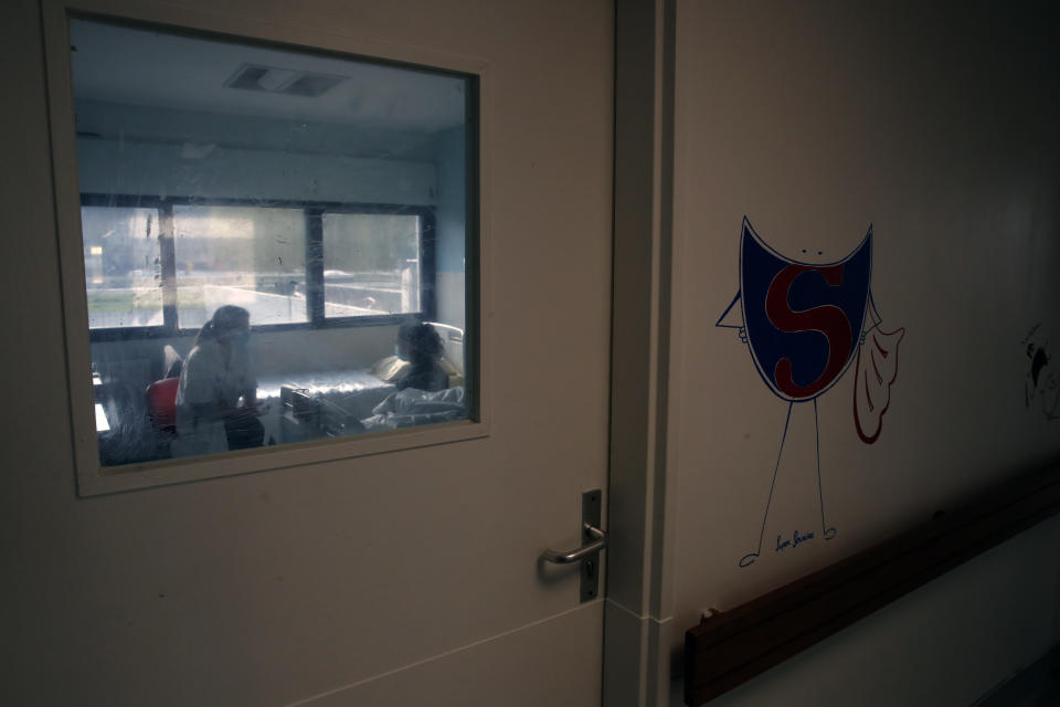 Psychiatrist Coline Stordeur speaks with a young girl in her room in the pediatric unit of the Robert Debre hospital, in Paris, France, Tuesday, March 2, 2021. France's busiest pediatric hospital has seen a doubling in the number of children and young teenagers requiring treatment after attempted suicides. Doctors elsewhere report similar surges, with children — some as young as 8 — deliberately running into traffic, overdosing on pills and otherwise self-harming. (AP Photo/Christophe Ena)