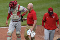 Cincinnati Reds catcher Tyler Stephenson, left, is helped by a team trainer as he leaves the team's baseball game against the Pittsburgh Pirates with an injury during the third inning in Pittsburgh, Saturday, May 14, 2022. (AP Photo/Gene J. Puskar)