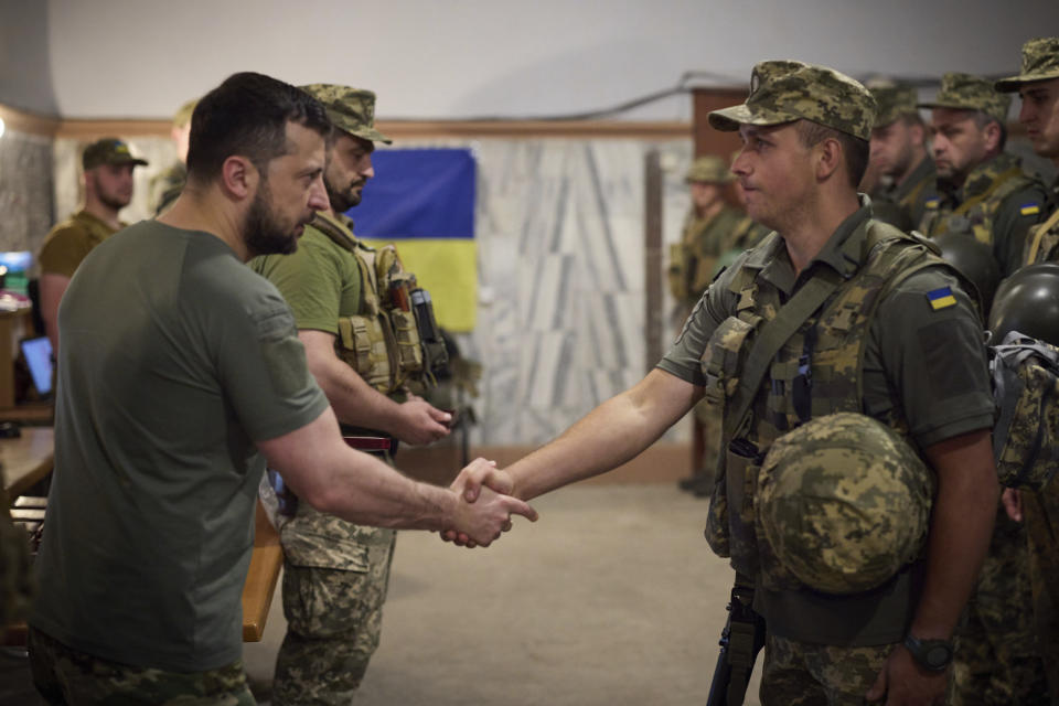 In this photo provided by the Ukrainian Presidential Press Office on Friday, July 8, 2022, Ukrainian President Volodymyr Zelenskyy, left, awards a serviceman as he visits the war-hit Dnipropetrovsk region. (Ukrainian Presidential Press Office via AP)