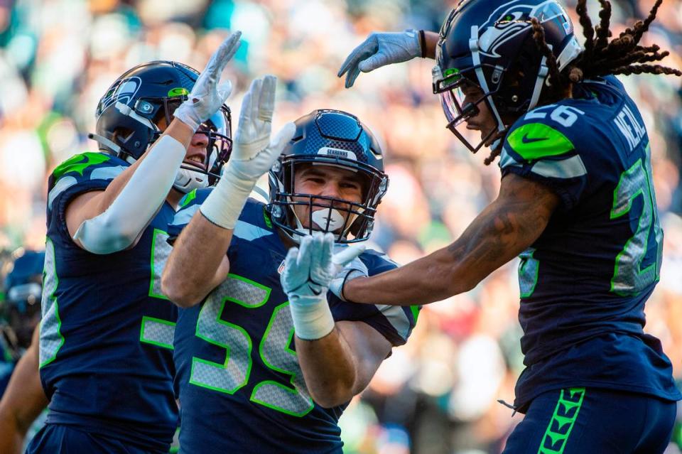 Seattle Seahawks linebacker Jon Rhattigan (center) celebrates with Seattle Seahawks defensive back Ryan Neal (right) after making a tackle on a kick-off return in the third quarter of an NFL game against the Jacksonville Jaguars on Sunday at Lumen Field in Seattle.