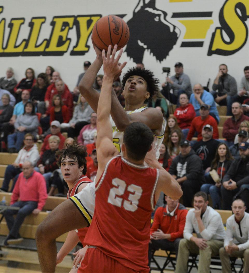 Tri-Valley's Terrell Darden shoots over Sheridan's Andon Hamner during Friday's MVL Big School Division game at Tri-Valley. The Scotties won 52-36.